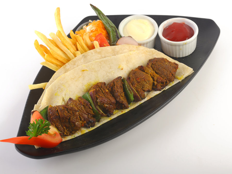Tikka kebab skewers on bread